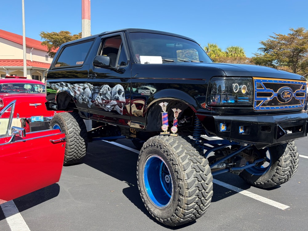 Lifted black SUV with custom skull artwork and large off-road tires